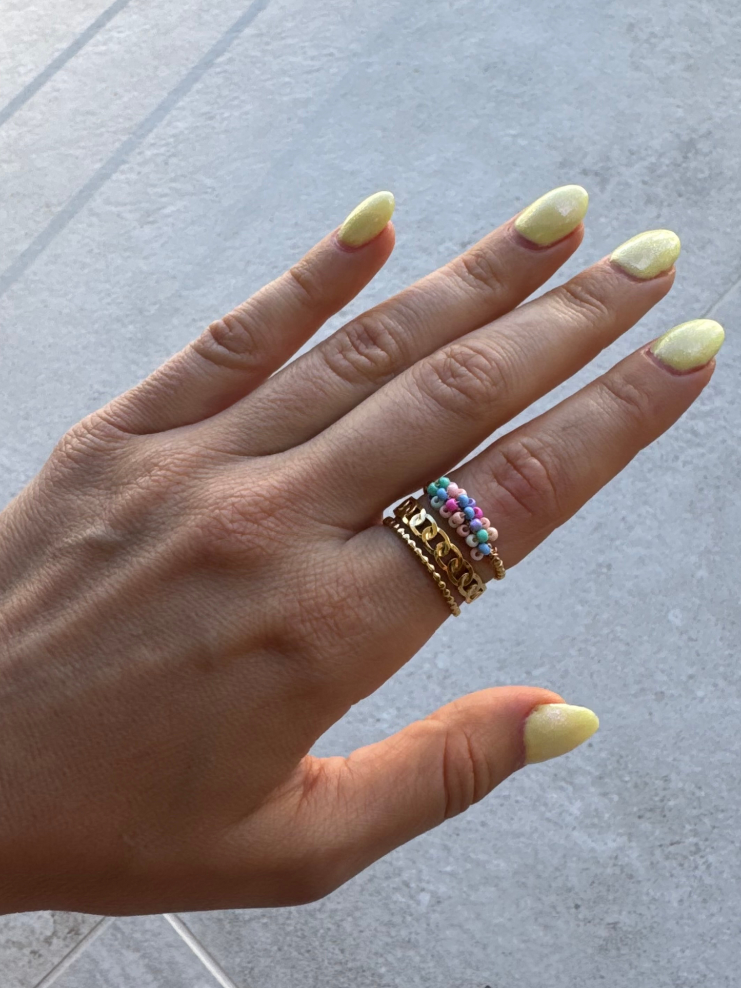 Anel dourado e missangas pequenas coloridas