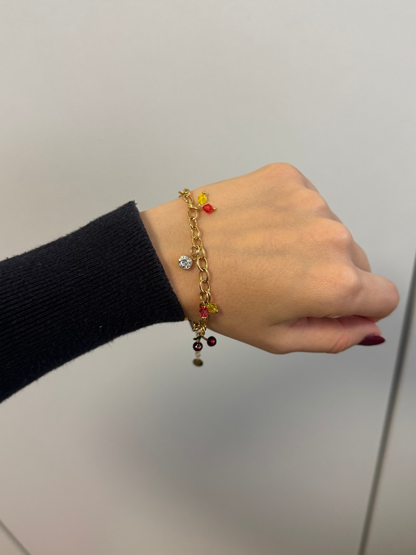 Pulseira dourada com pendentes coloridos